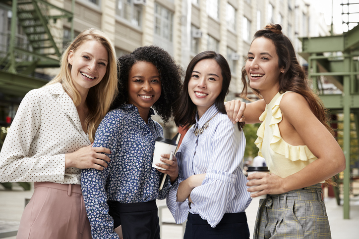 Four female coworkers smiling to camera outside The Corporate Sister